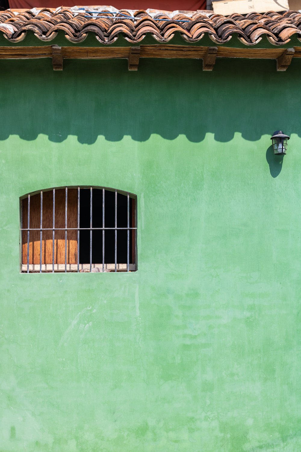 black metal window frame on green concrete wall