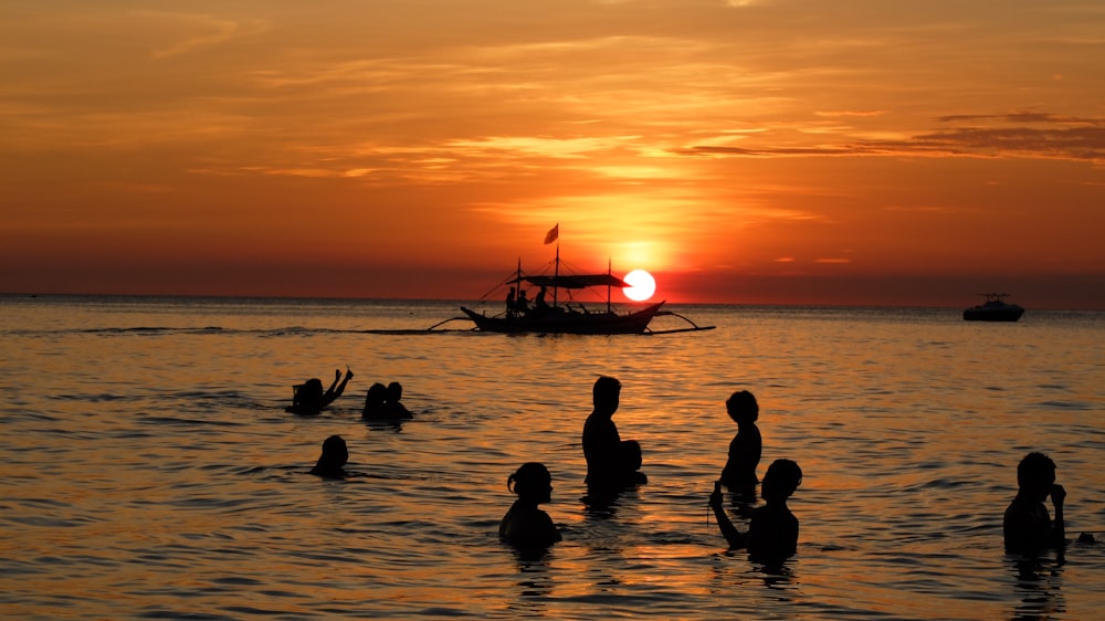 silhouette of people on beach during sunset