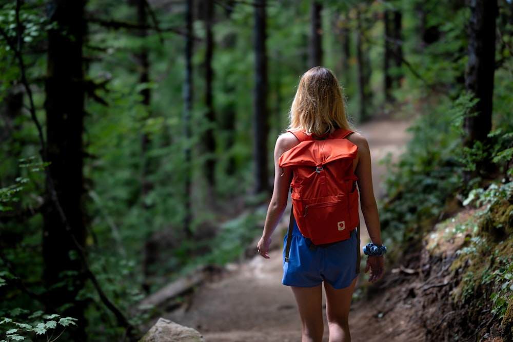 woman in blue denim shorts walking on pathway during daytime