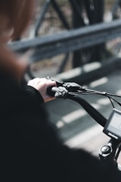 person in orange long sleeve shirt riding on motorcycle during daytime