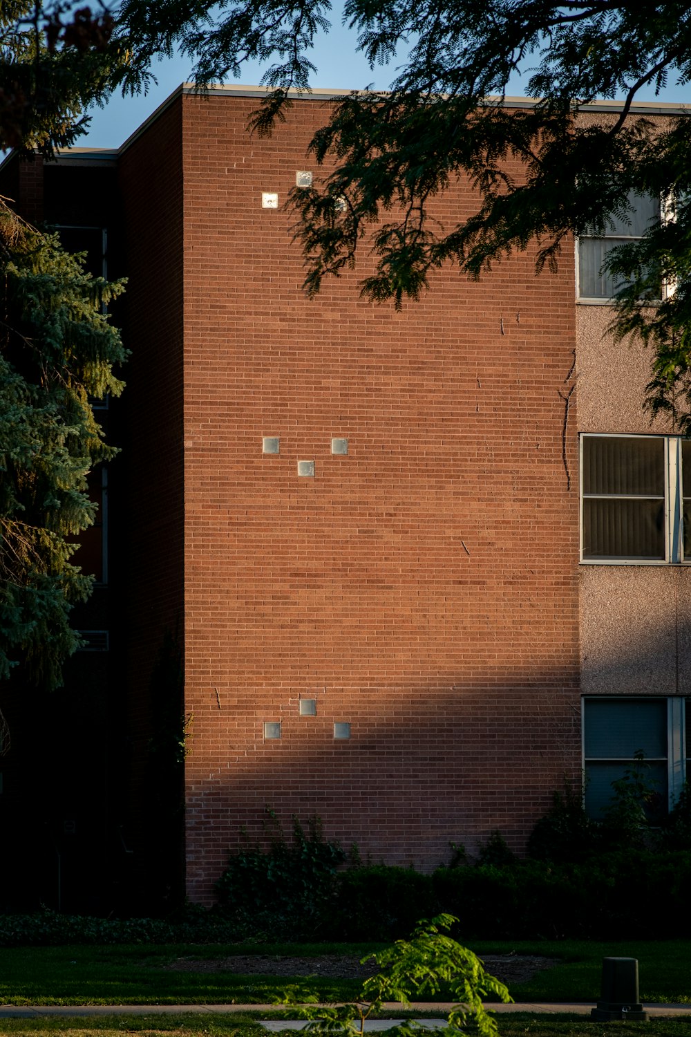 brown brick building with green trees