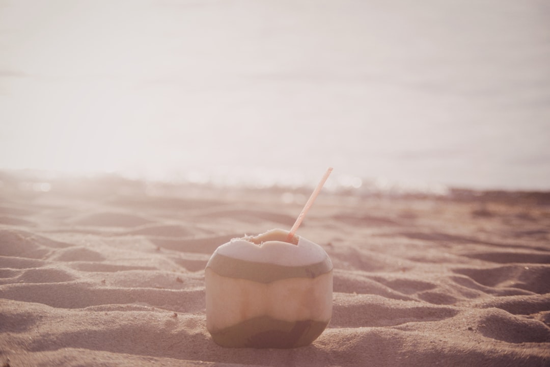 white and brown round container on brown sand