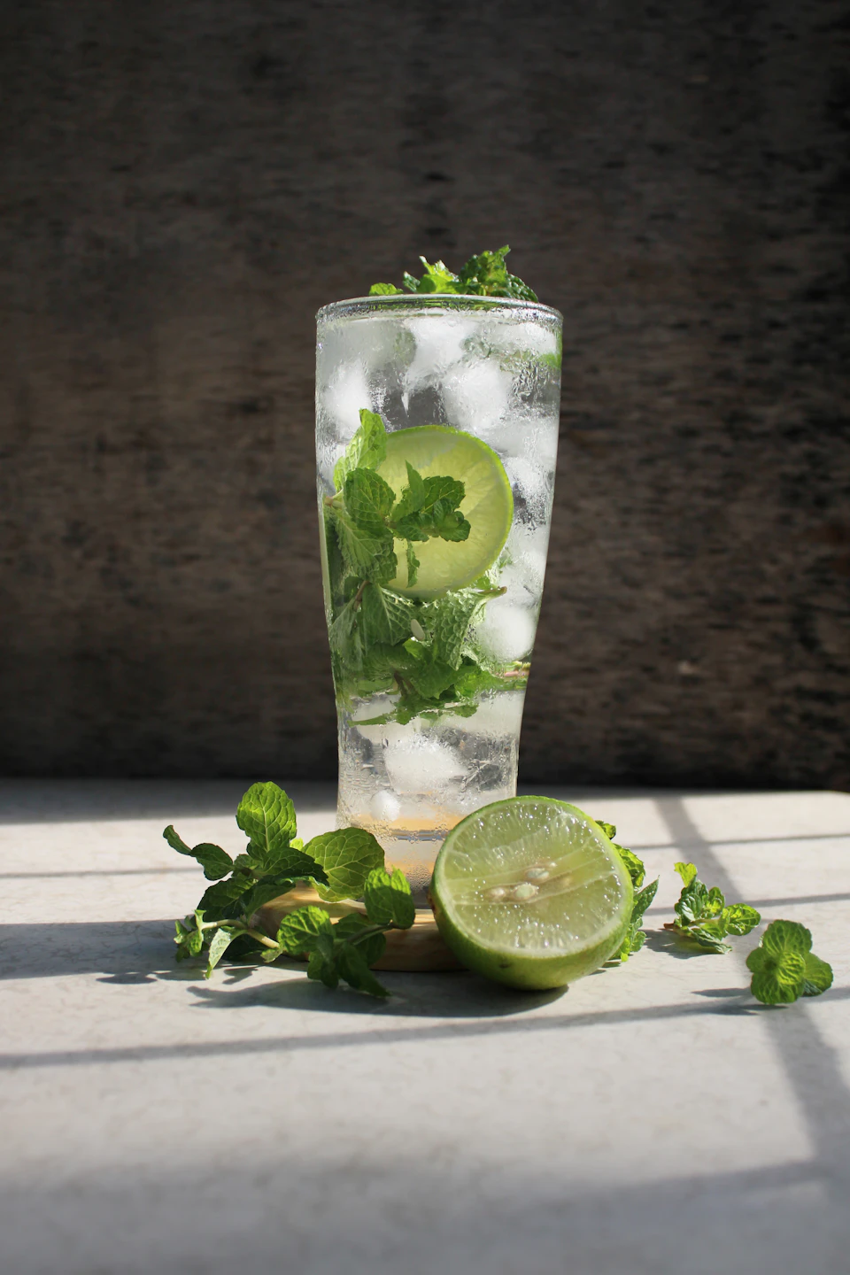 Tall glass filled with ice and water, topped with lime and mint slices