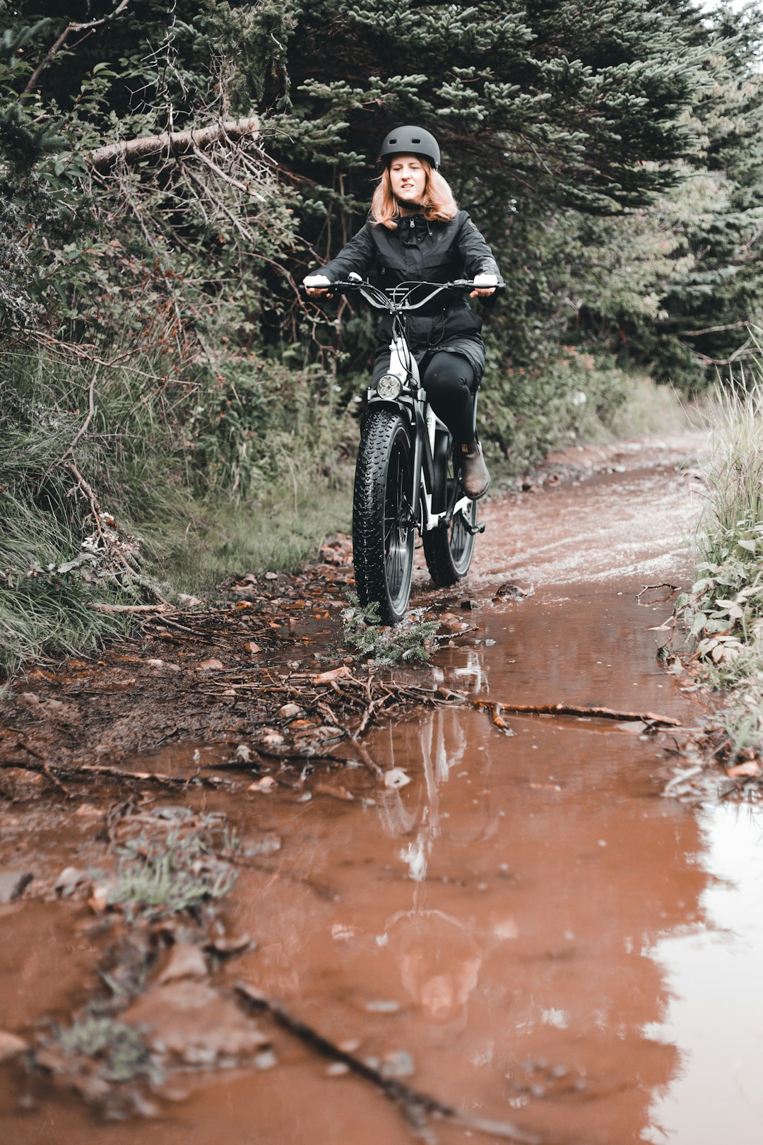 man riding bicycle on dirt road during daytime