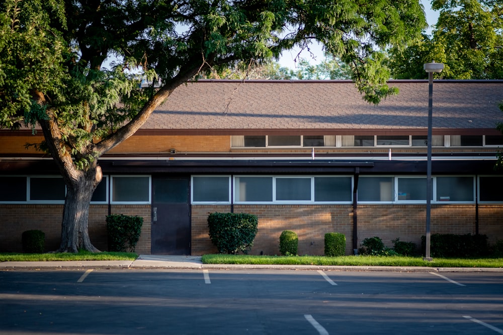 brown and white concrete building near green trees during daytime