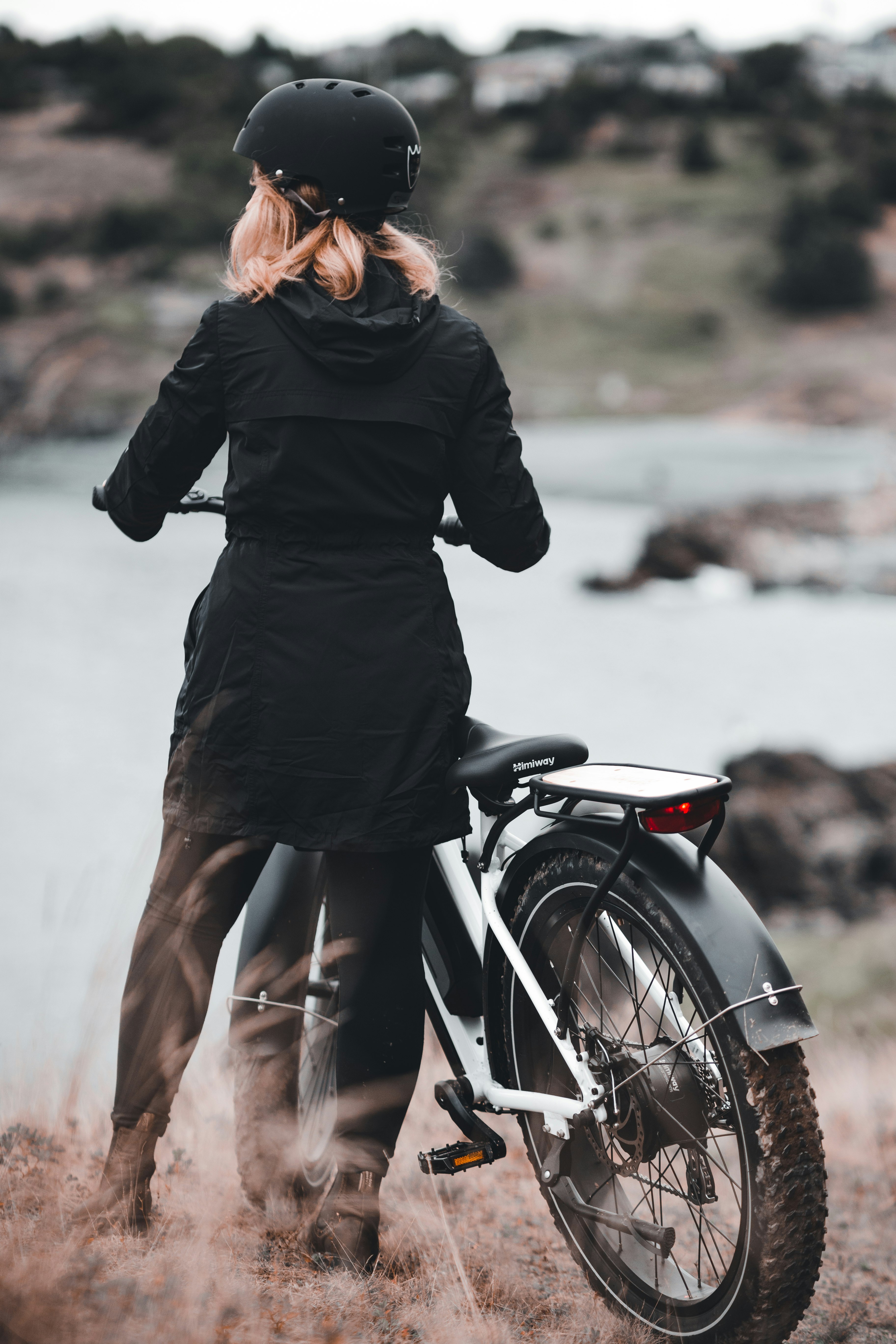 woman in black long sleeve dress riding on black motorcycle during daytime