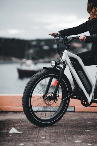 Photo of a happy person riding an electric bike confidently in an urban setting.