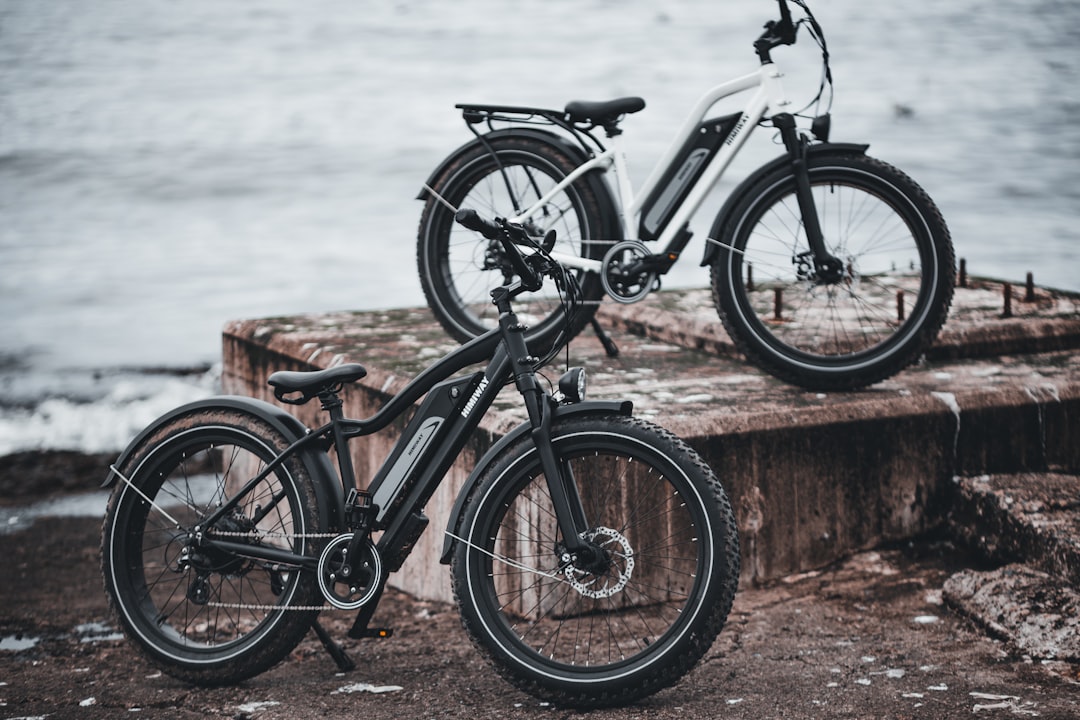 black and gray mountain bike leaning on brown wooden fence