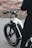 A satisfied customer standing next to a freshly repaired electric bicycle.