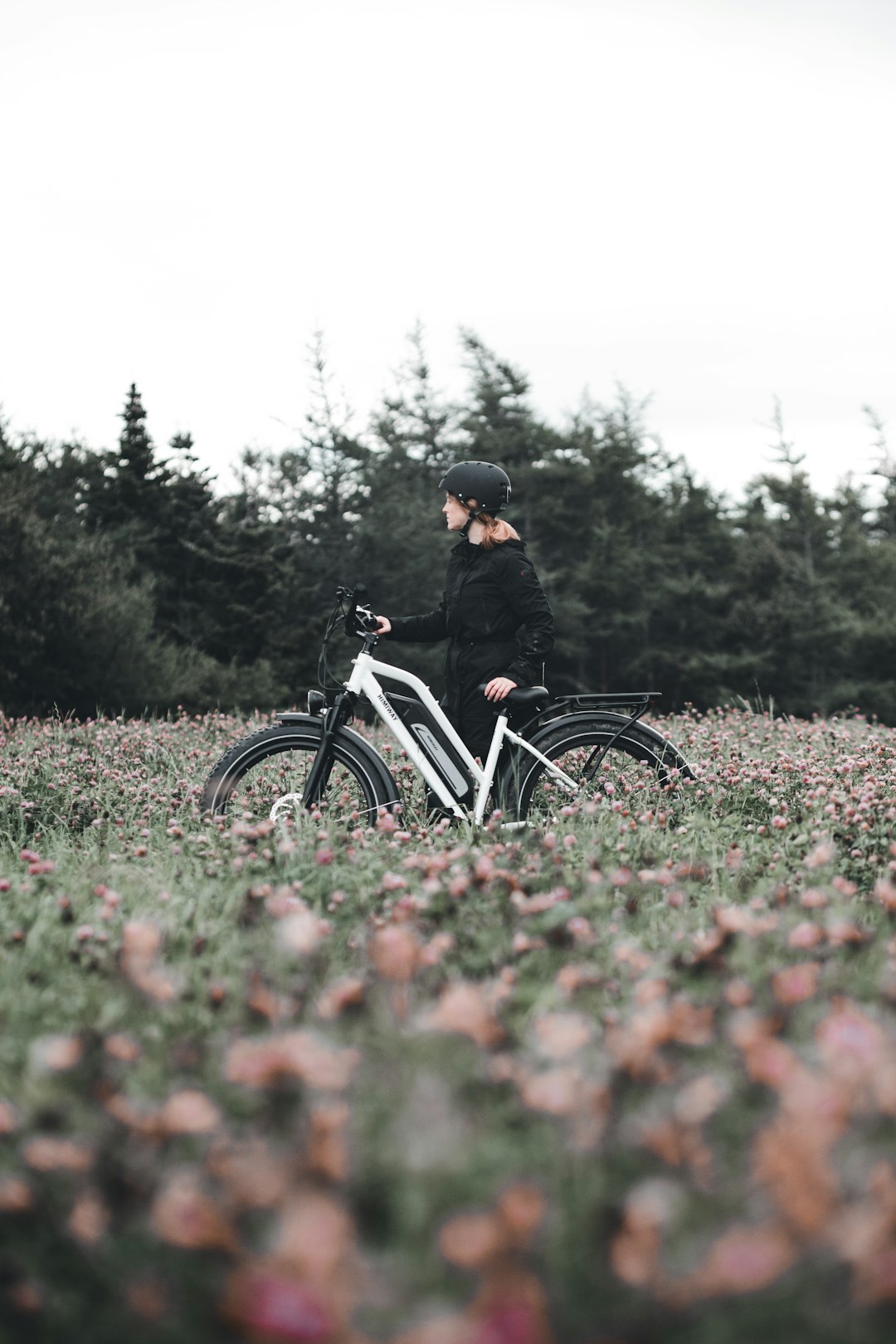 man in black jacket riding on bicycle on green grass field during daytime