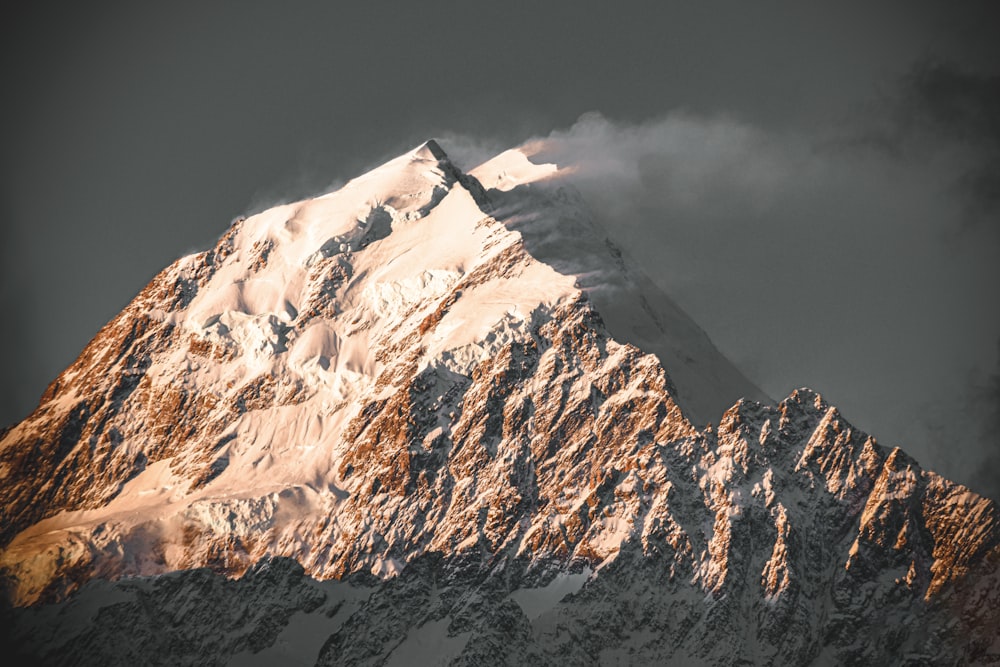 snow covered mountain under cloudy sky during daytime