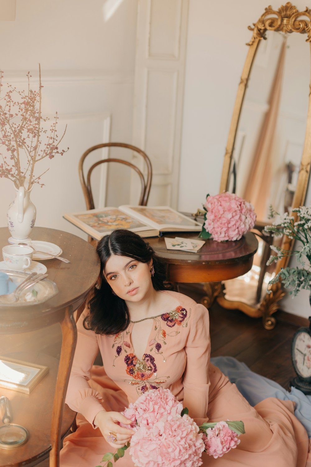 woman in pink and white floral dress sitting on chair