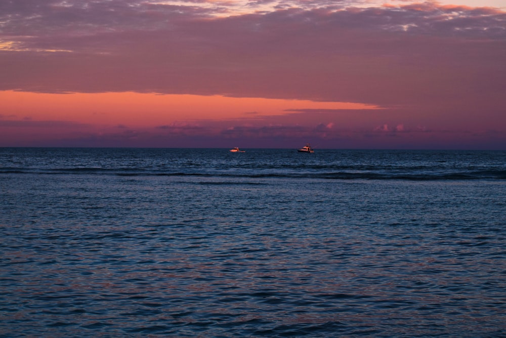 silhouette of person on sea during sunset