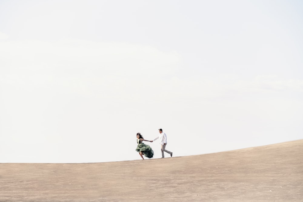 2 person riding on horse on brown sand during daytime