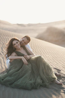 Happy couple enjoying a desert safari with golden dunes in the background.