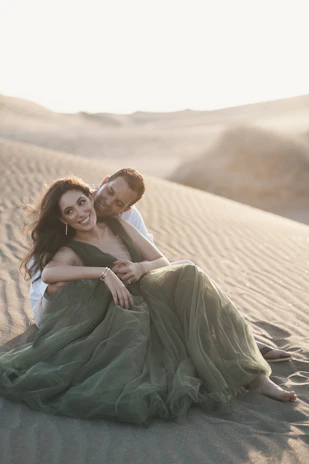 Happy couple enjoying a desert safari with golden dunes in the background.