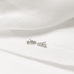 A sparkling lab-grown diamond stud earring set against a soft white background.