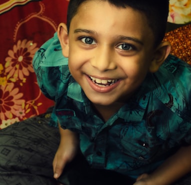 boy in green and black button up shirt smiling