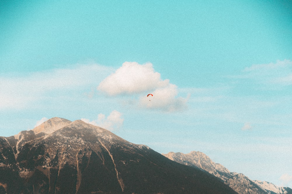 white clouds over brown and green mountain