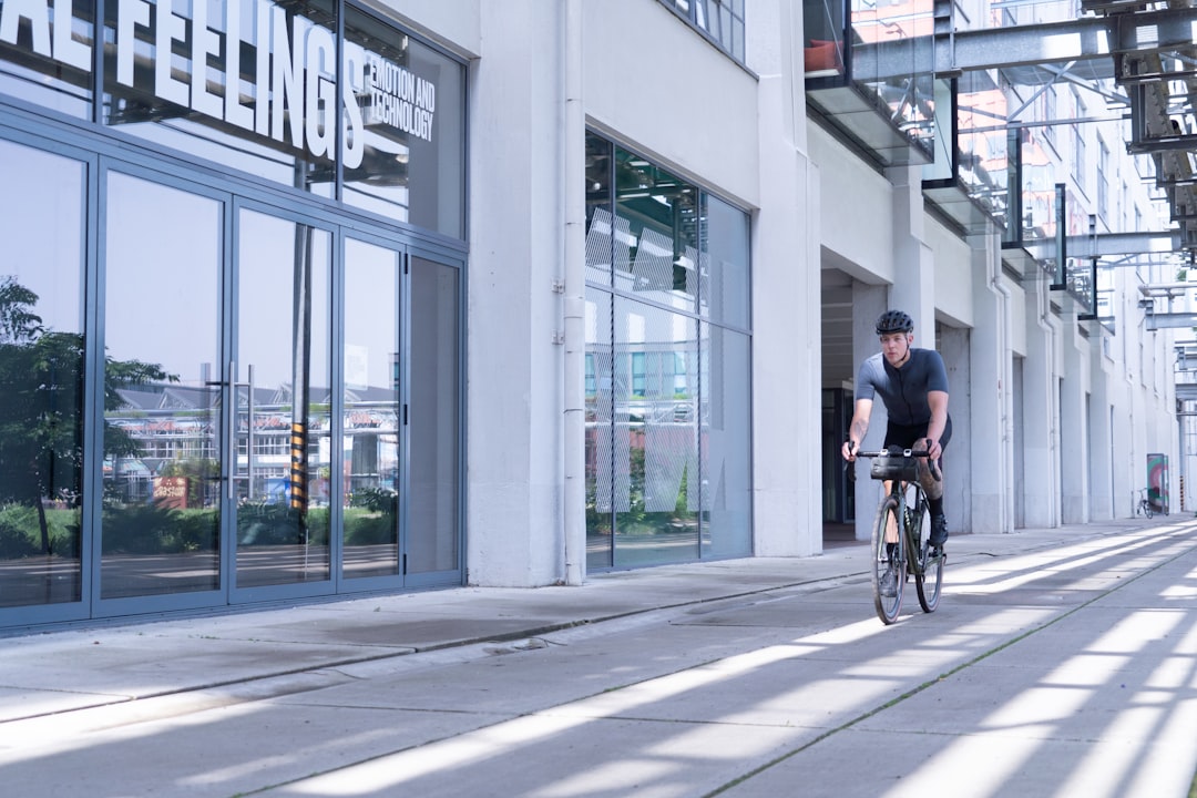 man in black shirt riding bicycle on road during daytime