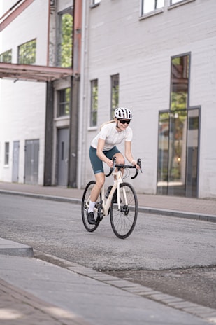 man in white t-shirt riding on bicycle during daytime