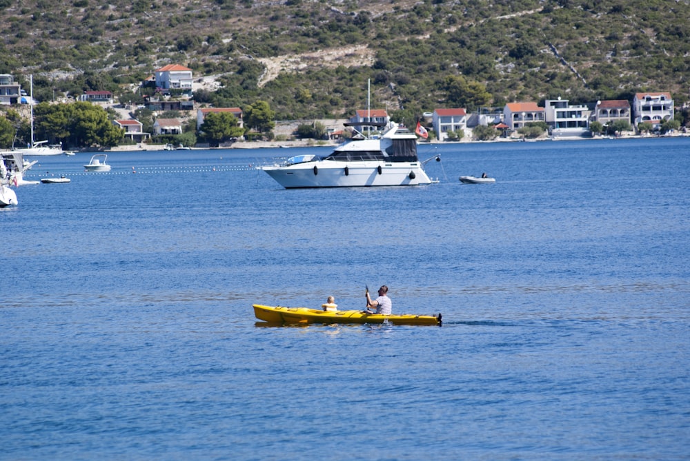 man in yellow kayak on blue sea during daytime
