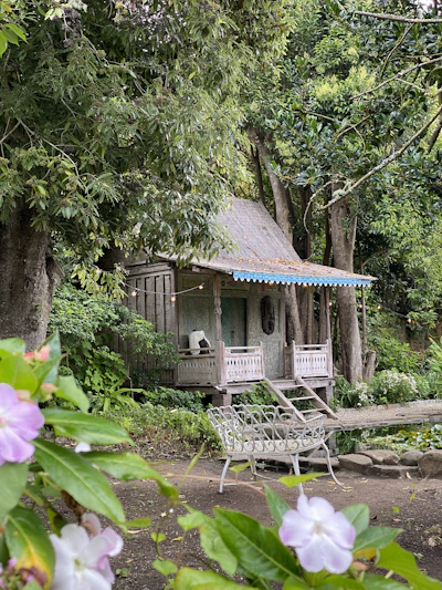 A cozy wooden cabin surrounded by lush greenery and colorful flowers at Recanto Serene.