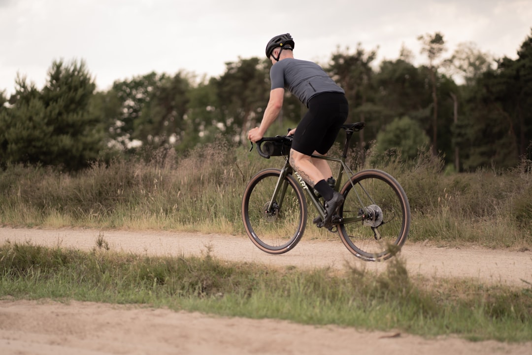 man in black t-shirt riding black mountain bike on brown field during daytime