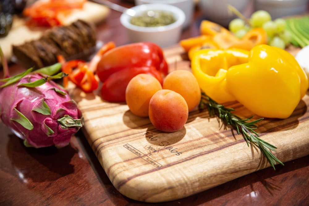 yellow bell pepper and red onion on brown wooden chopping board