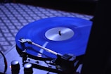 A vinyl record spinning on a turntable with a blue LED glow around it.
