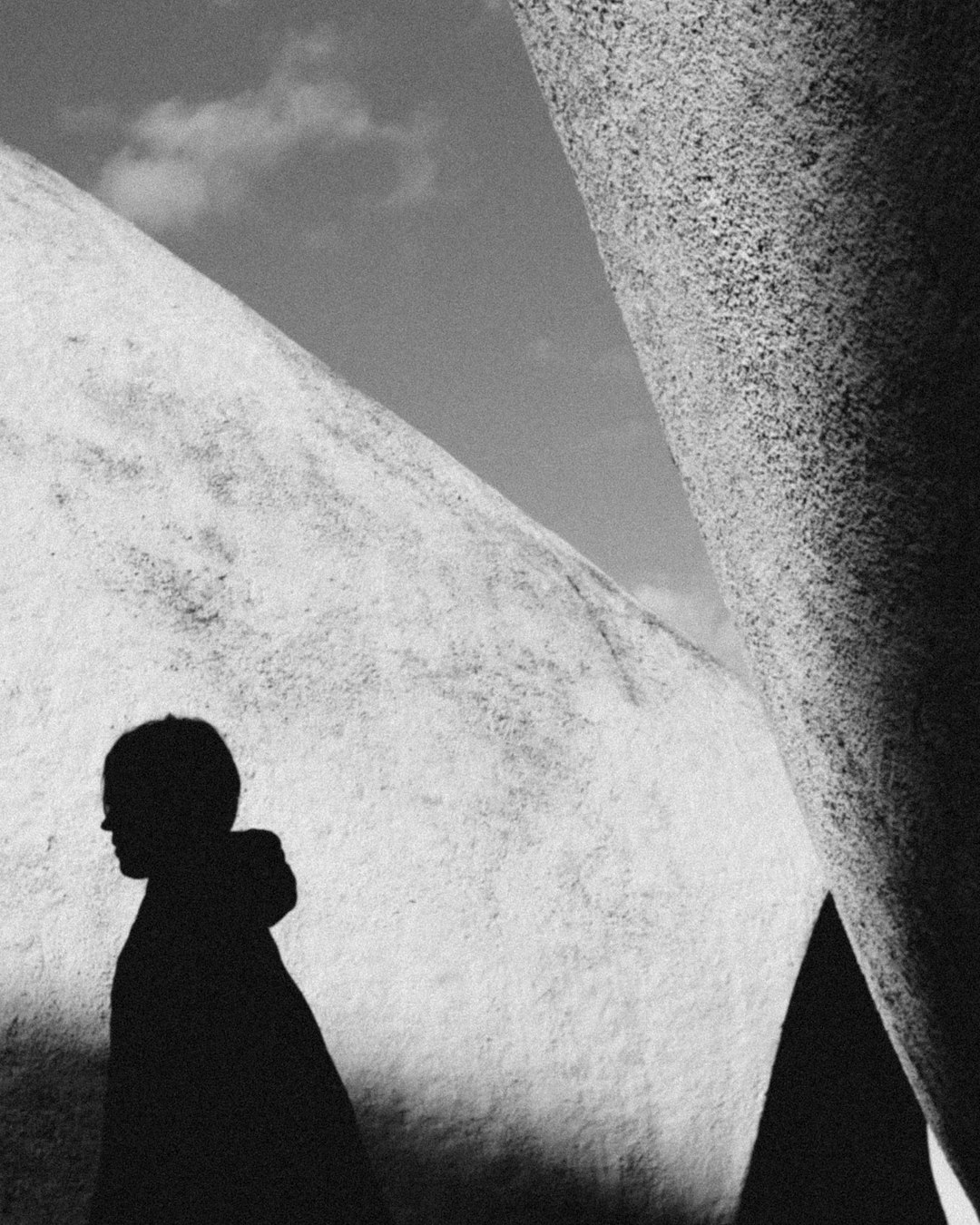 silhouette of man standing under gray sky