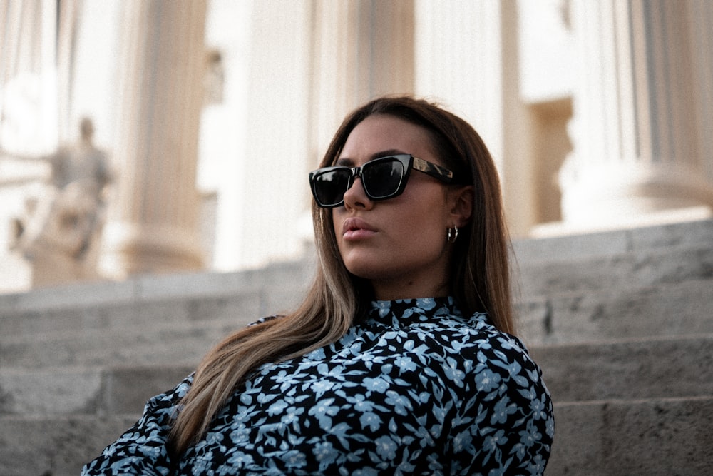 woman in blue and white floral shirt wearing black sunglasses