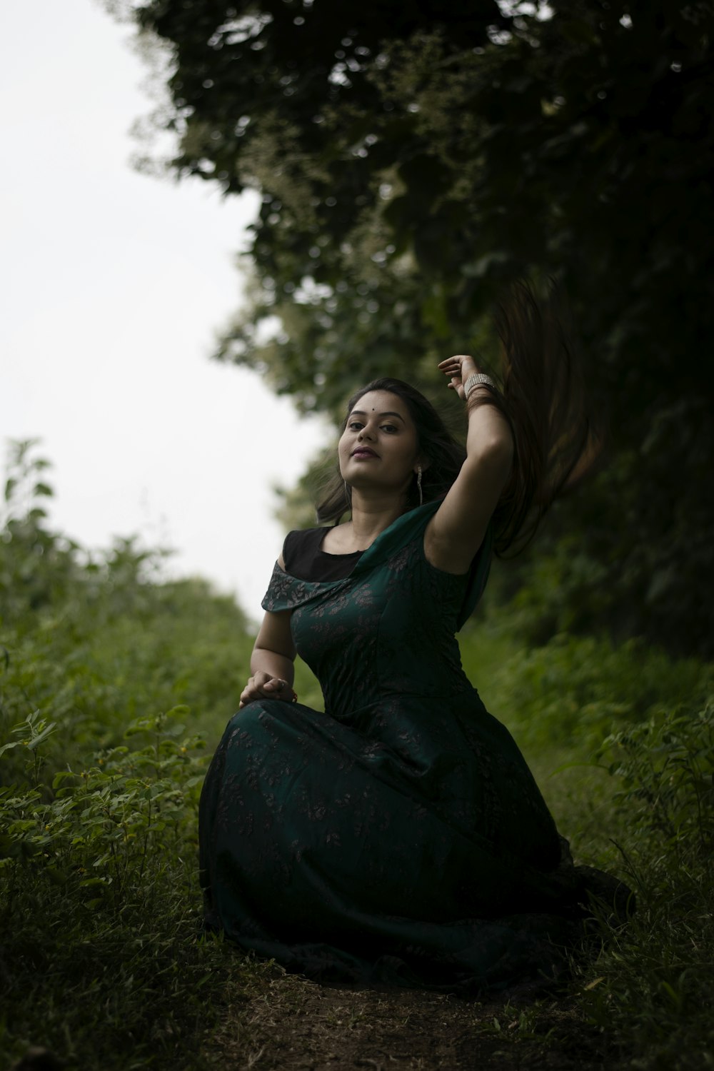 a woman in a dress sitting in the grass