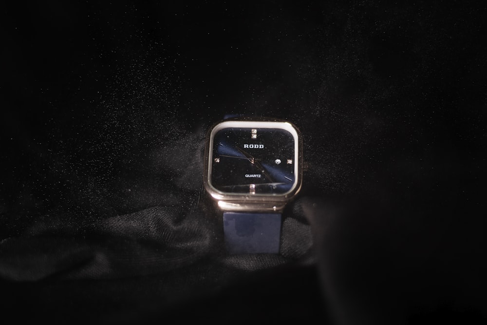 a watch sitting on top of a black cloth