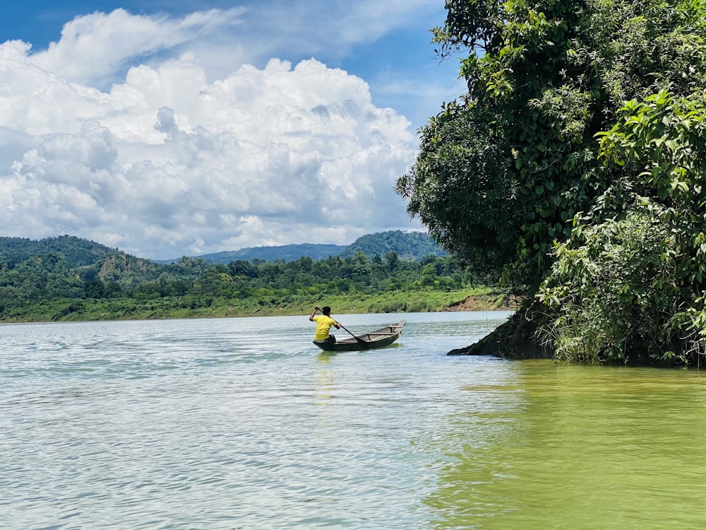 man in yellow shirt riding on yellow kayak on river during daytime