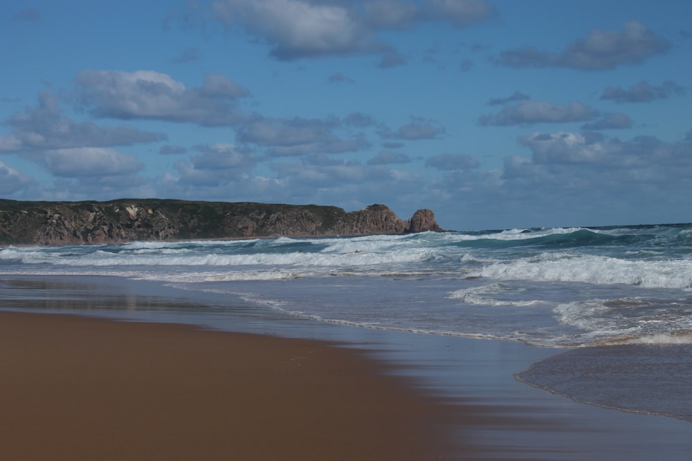 ocean waves crashing on shore during daytime