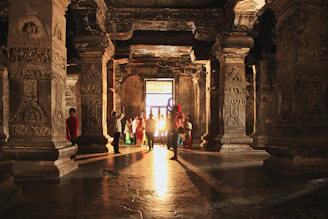 Sunlight streaming through ancient temple pillars, casting intricate shadows on the stone floor.