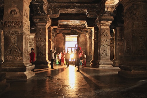 Ancient temple carvings illuminated by warm saffron light.