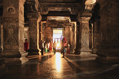Shadowy interior of a temple room with faint glowing hieroglyphs and Guarani motifs on the walls.