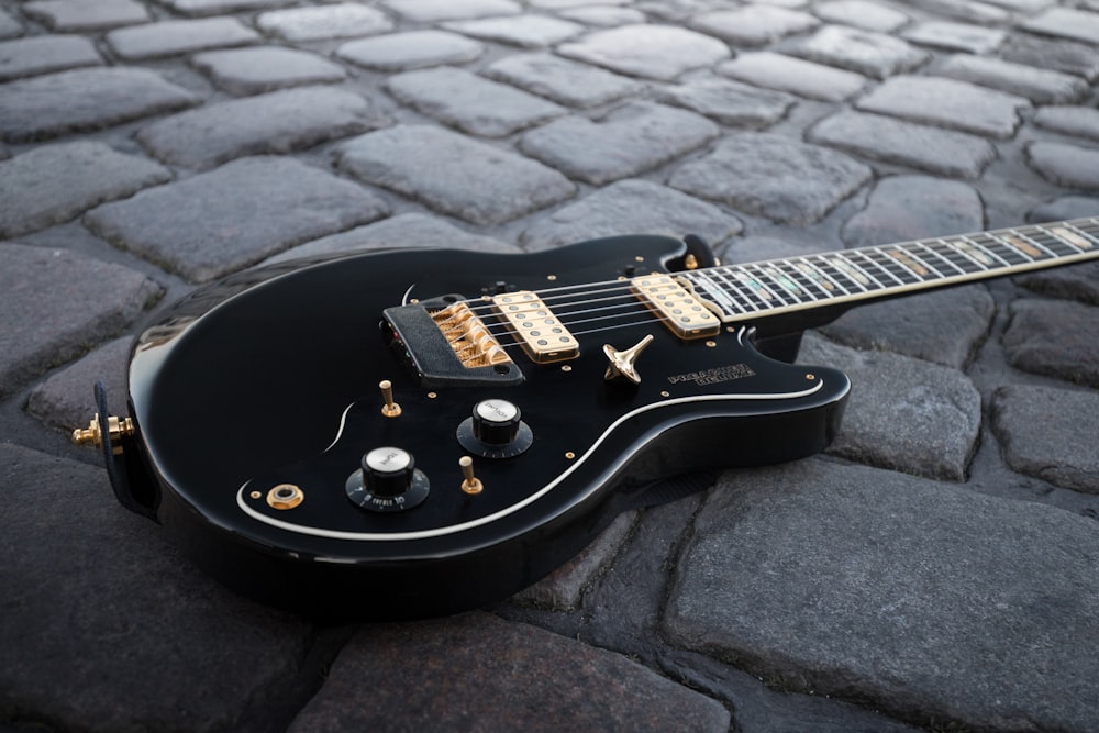 black and white stratocaster electric guitar on black and gray concrete floor