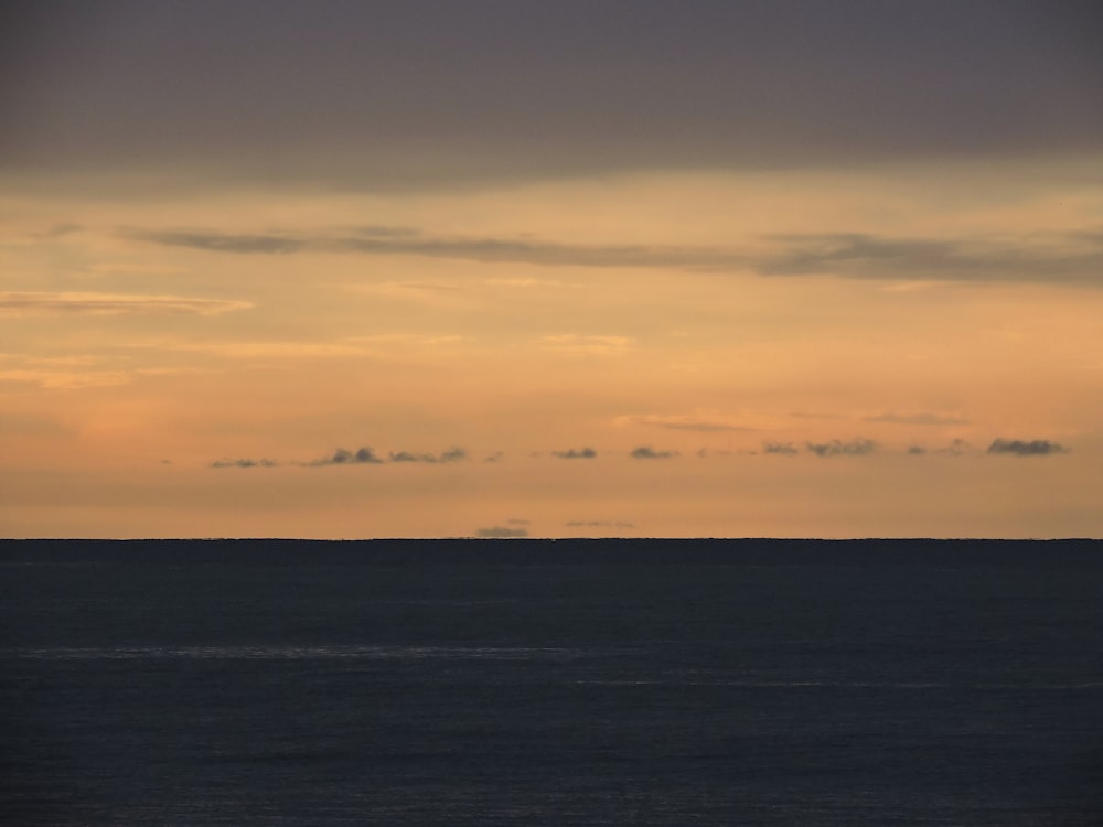 body of water under cloudy sky during daytime