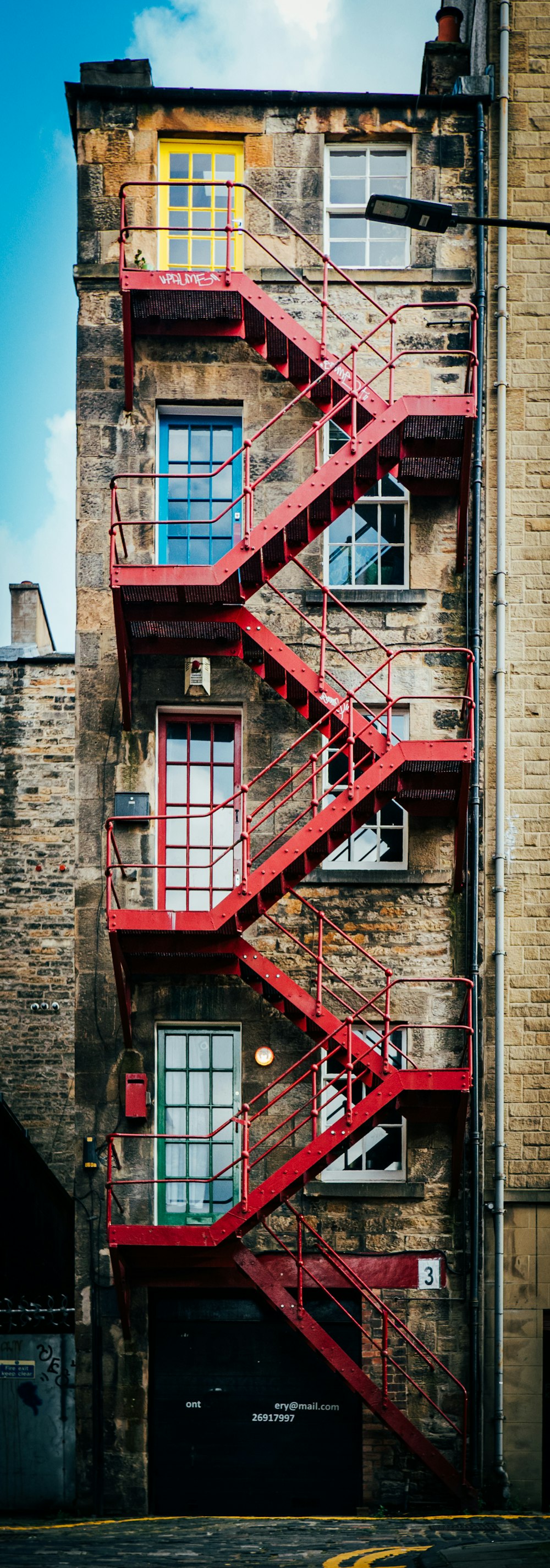 red metal ladder on brown brick building