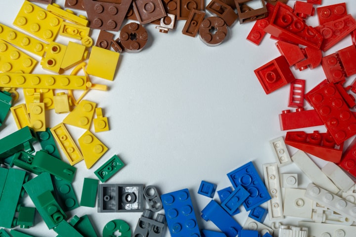 Different colored Lego bricks on a grey background