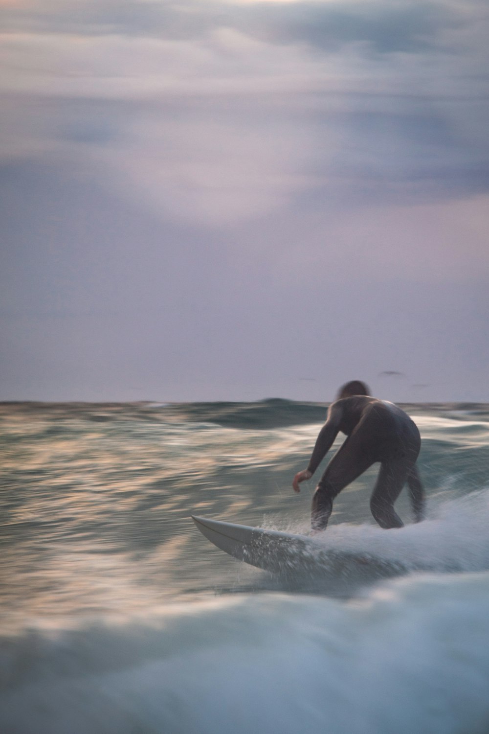 man surfing on sea waves during daytime