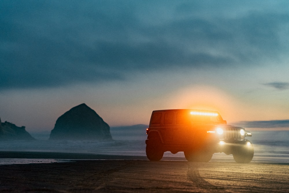 orange truck on beach during sunset