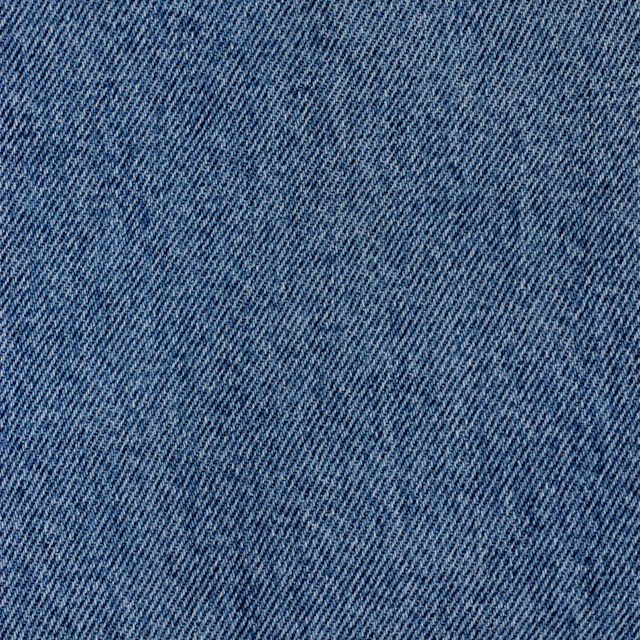 A close-up of blue denim fabric with a visible diagonal twill weave