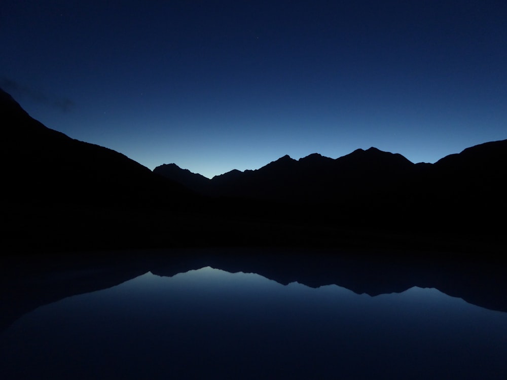 silhouette of mountain during night time