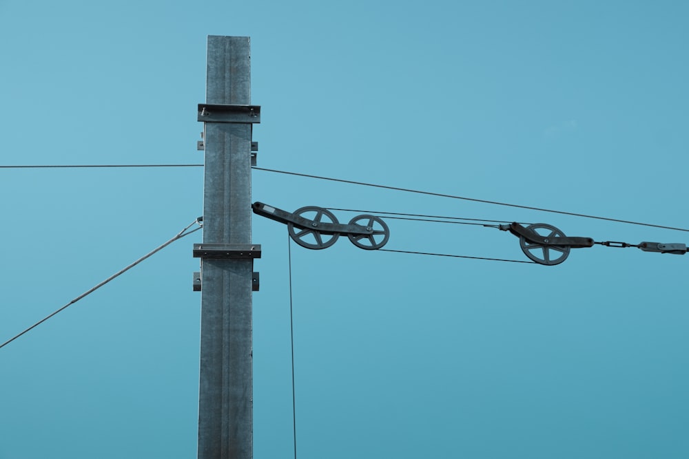 gray electric post under blue sky during daytime