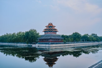 green and brown temple near body of water during daytime