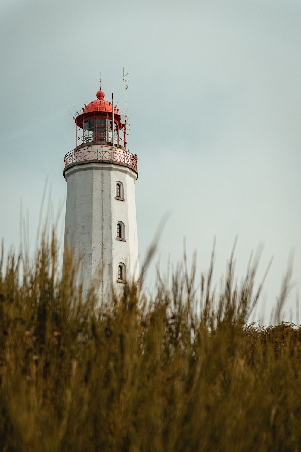 white and red lighthouse under white sky during daytime